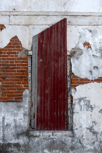 Window in old building covered with rusty corrugated iron for use as a background
