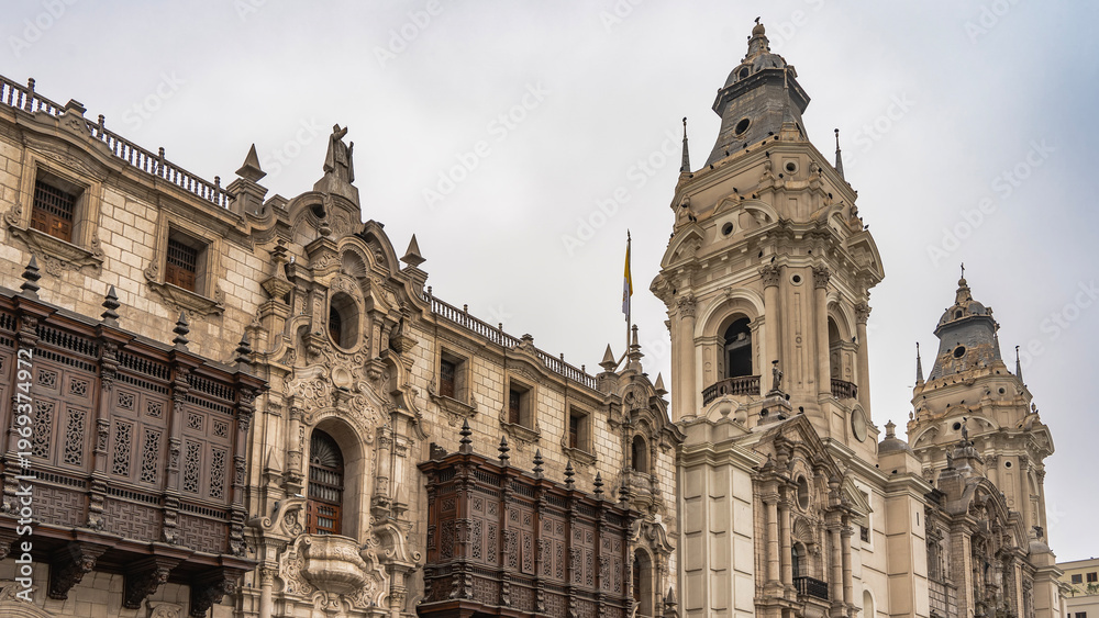 Fototapeta premium Old Spanish Colonial Revival architecture. Basilica and Convent of San Francisco. Columns, arches, stone carvings, statues on the facade. Wooden barred balconies. Domes, crosses against the sky. Peru
