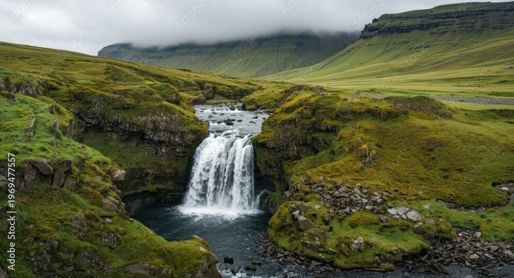 Fototapeta premium A quiet waterfall set among smooth green hillsides