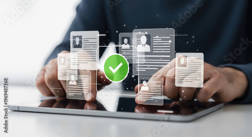 Professional reviewing digital employee profiles on a tablet with verification mark
