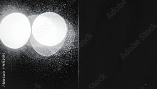 Abstrakte Darstellung von zwei hellen, überlappenden Lichtkreisen auf dunklem, strukturiertem Hintergrund, die eine futuristische Stimmung erzeugen.