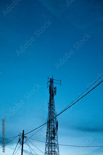 High BTS tower facilitating wireless communication against a blue twilight sky