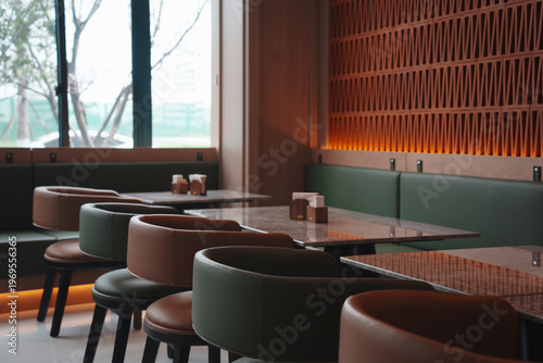 Schilderij op canvas Modern café interior with green and brown color scheme featuring booth seating a