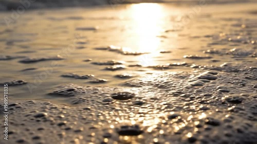Ocean wave foam on sandy beach golden sunlight reflection serene coastal landscape