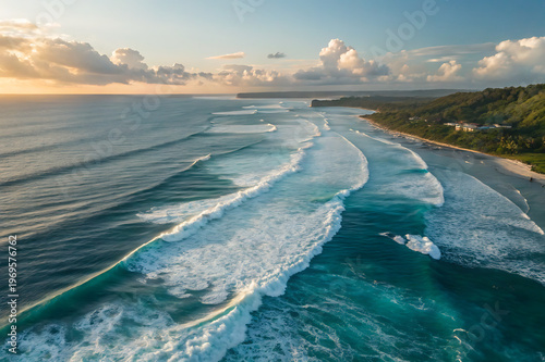 Aerial view of a beautiful tropical coastline with long rolling waves at sunset in bali, indonesia