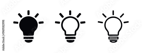 Bright idea and innovation lightbulb icon set with radiating light beams.