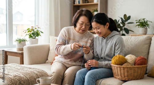 Asian Grandmother Teaching Granddaughter Knitting on Sofa in Modern Living Room