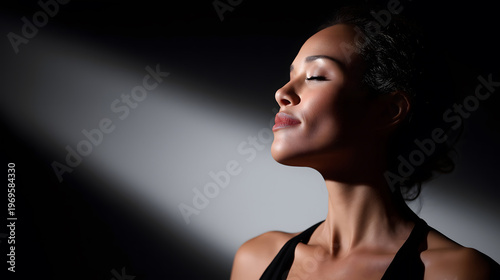 Woman with closed eyes in dramatic light, mindfulness and serenity concept