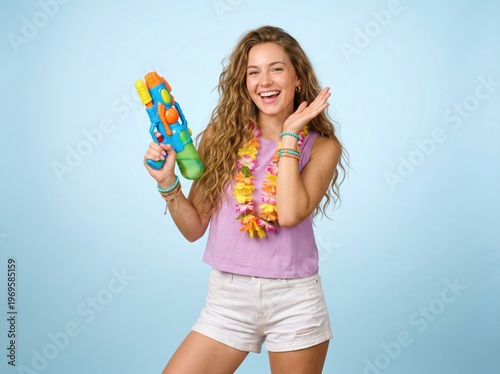 Happy young woman holding a water gun and flower lei for Songkran summer vacation