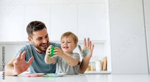 Father and son playing with toy cars in a modern kitchen with young boy