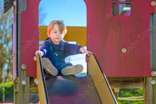 Toddler Playing On Playground Slide
