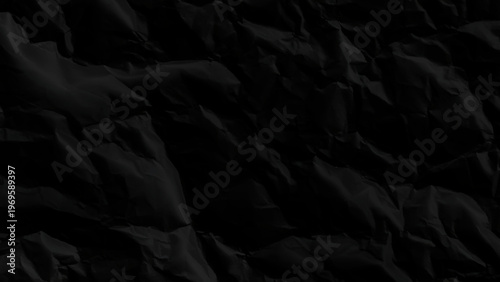 Closeup of crumpled black paper texture with creases and folds detailed abstract background