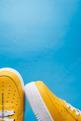 Paire de baskets jaunes sur fond bleu uni avec espace pour texte