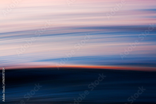 Abstract ocean motion with sunset light streak across wave