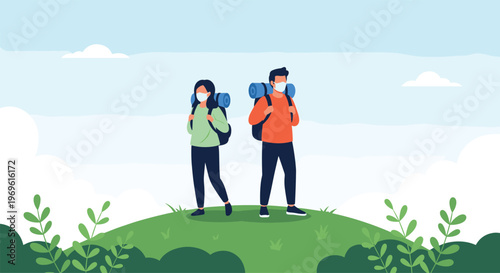 Two adventurous hikers wearing protective masks and carrying backpacks stand on top of a green hill looking at the horizon.