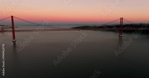 Panoramic sunset skyline view of Lisbon Portugal 25th April red suspension bridge famous iconic landmark