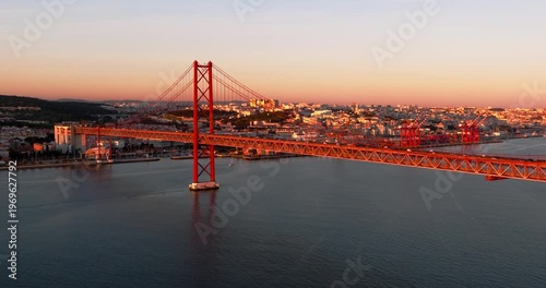 Wide aerial sunset perspective of Lisbon Portugal 25th April red suspension bridge famous iconic landmark