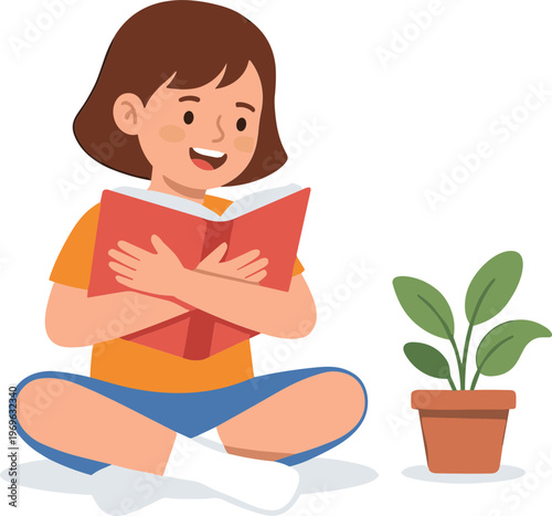 A girl reads a book sitting cross-legged indoors with a plant nearby.