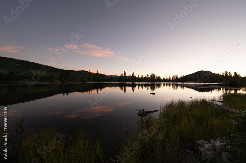 Tranquil alpine lake reflecting sunset sky at dusk near Estes Park