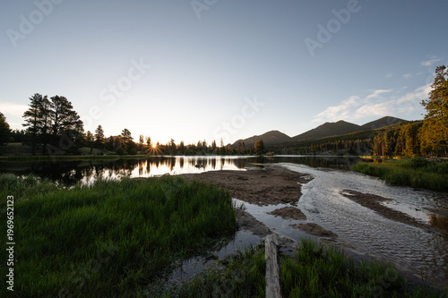 Sunrise reflecting on mountain lake surface in the Rockies