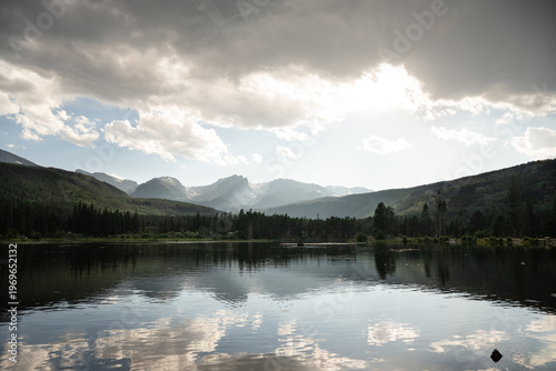 Sun rays breaking through clouds over a high altitude mountain lake