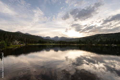 Rocky Mountains lake reflecting sunset clouds at dusk