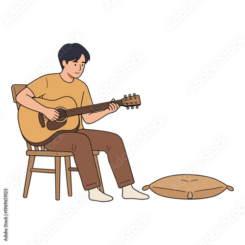 Man sits on chair playing acoustic guitar next to cushion indoors