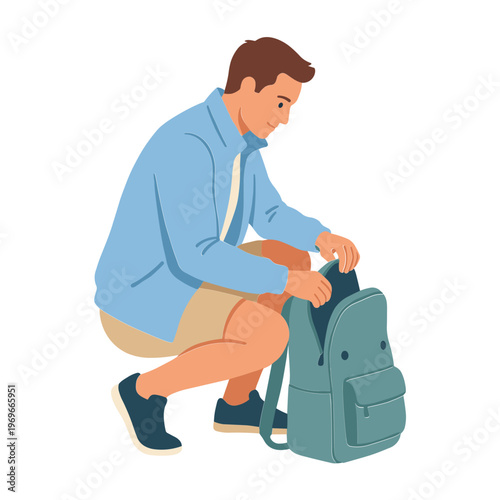 Man crouches down to pack a backpack with casual clothes on.