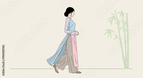 Woman in Vietnamese Ao Dai walking by bamboo