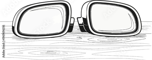 Two large, reflective side mirrors with dark borders sit on a surface with wood grain patterns