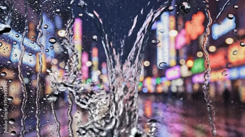 Raindrops on window colorful city lights blurred abstract bokeh background vibrant urban night wet glass surface texture wallpaper atmosphere