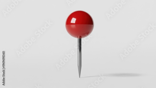 A single bright red pushpin or thumbtack stands vertically with a shiny metallic pin on a clean smooth white background under soft studio lighting creating a su