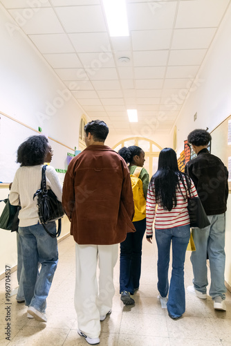 Group of diverse college students walking and communicating in a brightly lit school corridor, representing education and community