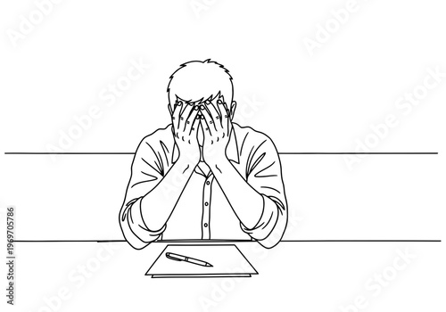 Man sitting at desk with hands on face looking stressed or frustrated