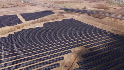 Large Scale Solar Farm Aerial View with Photovoltaic Panels Near Highway