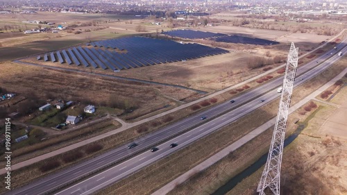 Aerial View of Solar Farm Near Highway with Power Lines and Rural Landscape