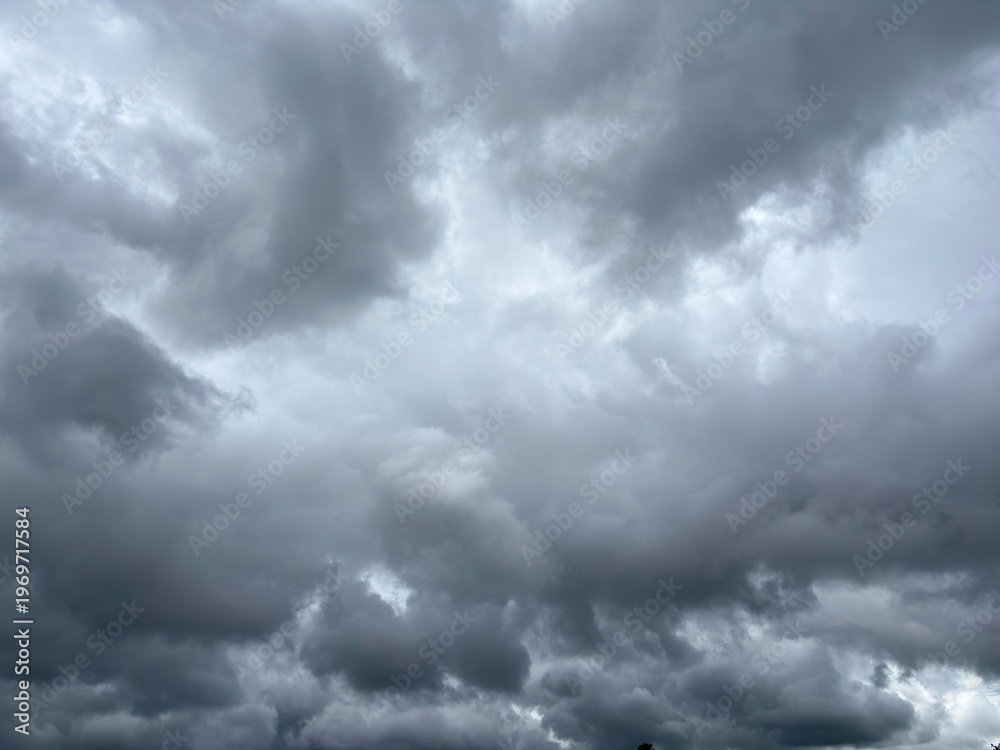 Obraz premium Wide landscape view of dark rain clouds over tropical hills and coconut trees.
