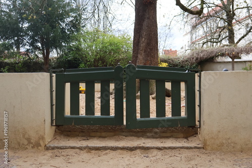 Children’s sandbox with small wooden gates, creating a playful outdoor environment for kids. Simple playground element symbolizing early childhood activities, imagination, and outdoor play, Berlin, 
