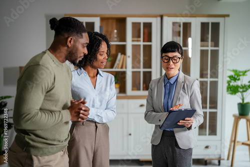 Foto Real estate agent meeting young couple discussing property investment
