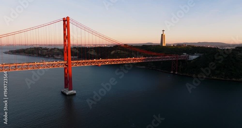 Warm golden sunset across Lisbon Portugal 25th April red suspension bridge famous iconic landmark skyline