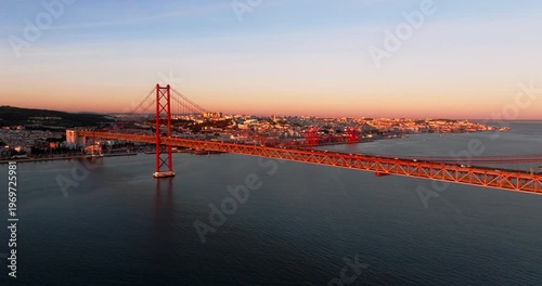Evening glow on Lisbon Portugal 25th April red suspension bridge famous iconic landmark and river