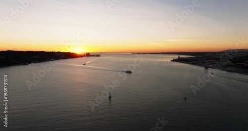 Warm sunset horizon framing Lisbon Portugal 25th April red suspension bridge famous iconic landmark