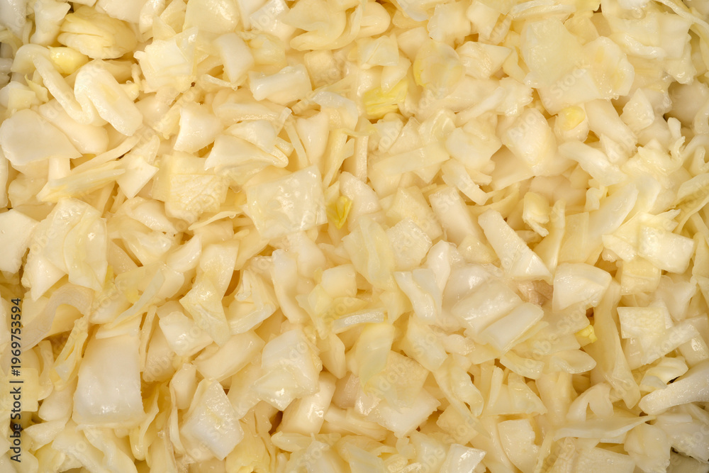 Fototapeta premium A detailed full frame background texture showing a pile of freshly chopped raw white cabbage pieces ready for cooking or salad