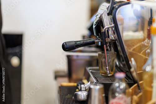 English: Close-up of a professional espresso coffee machine in a modern cafe, selective focus on the portafilter and steam wand with a blurred background.