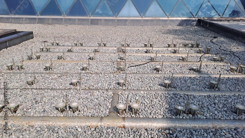 outdoor fountain system nozzles and lights on grey pebble stone background