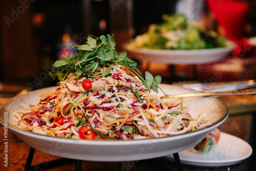 Horizontal Close-up of a Vibrant Asian Fusion Salad with Shredded Cabbage, Carrots, Peanuts, and Fresh Microgreens at a Professional Catering Event