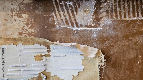 Tablou pe pânză Peeling paint and exposed plaster reveal a layered, textured surface on an old w