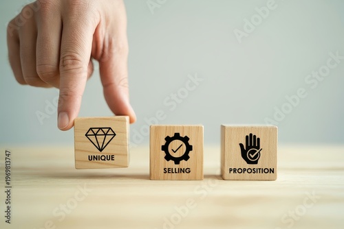 Hand placing wooden block with unique selling proposition USP on desk for business concepts