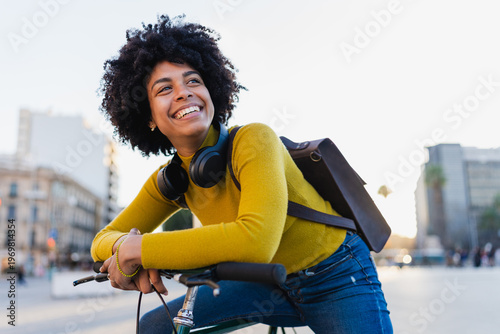 Happy black woman enjoying urban bicycle ride in city