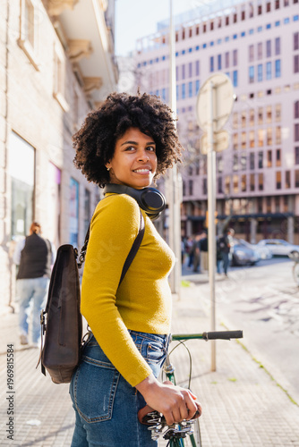 Happy young woman smiling with bicycle in city